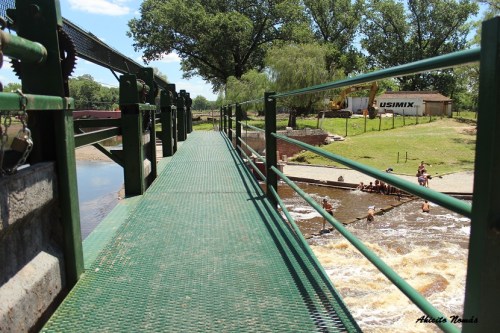 Desde la pasarela de las compuertas se observa como los niños juegan en el río.